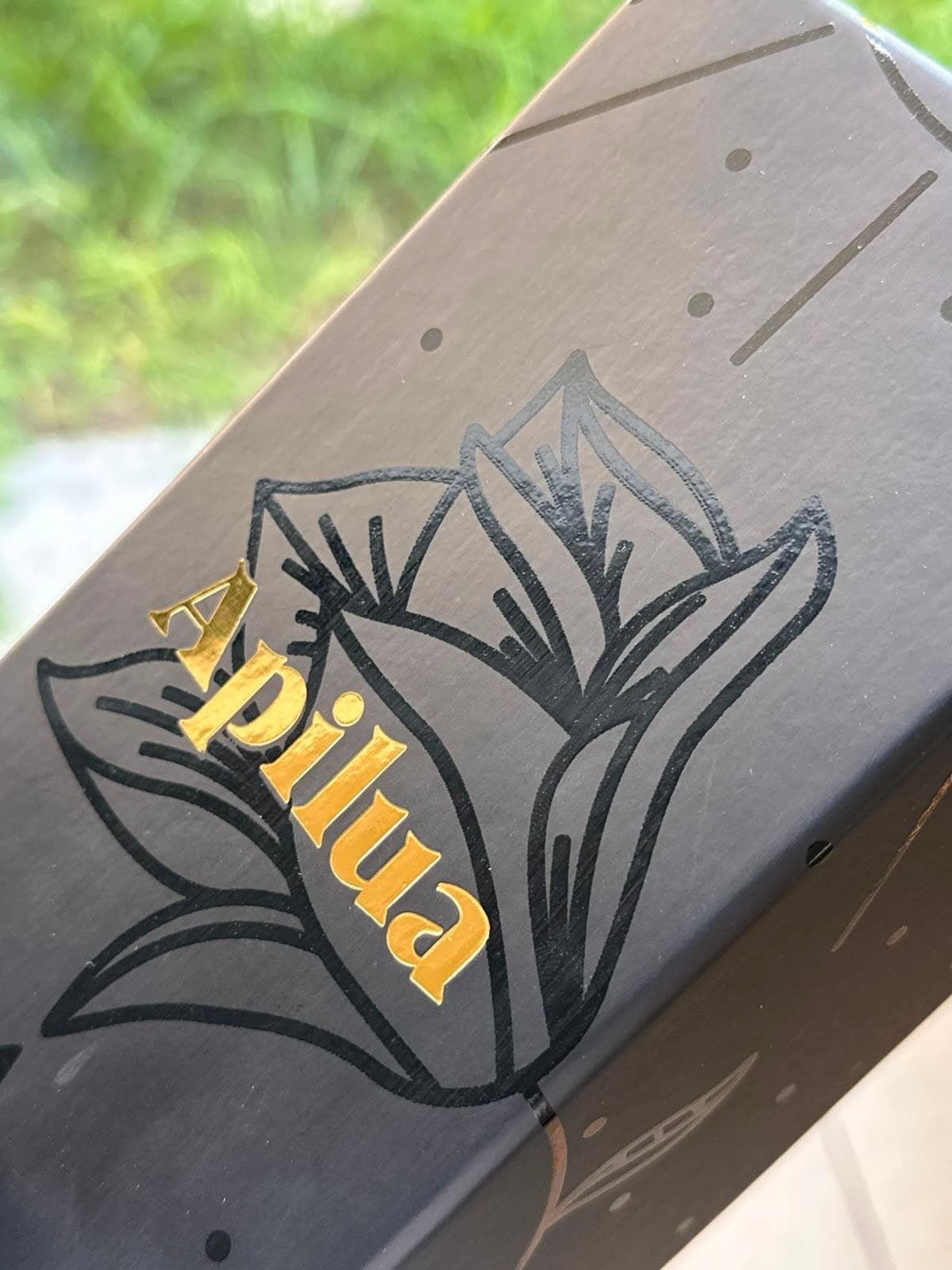 Apilua black carton with gold foil logo and spot gloss botanical artwork