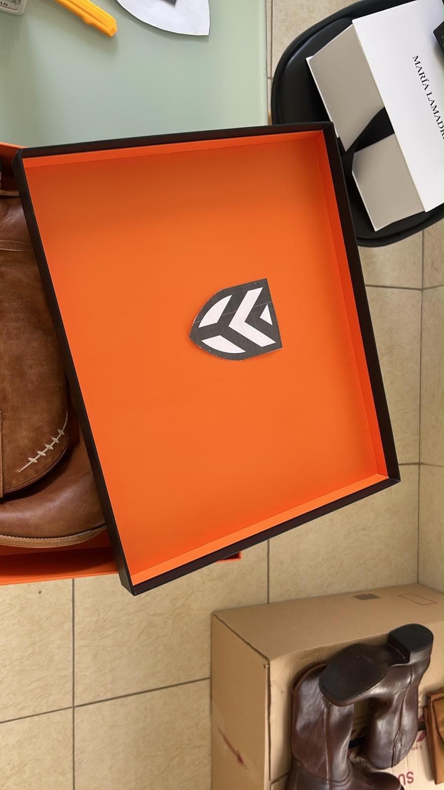 Footwear box lid interior in orange with printed logo